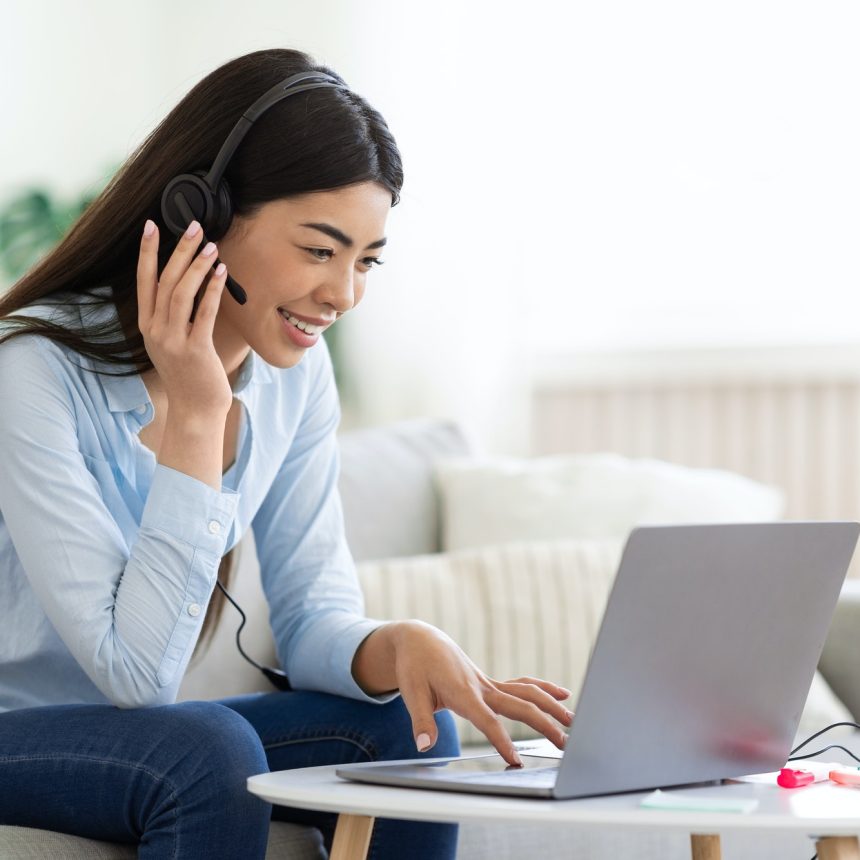 asian-woman-studying-foreign-languages-online-with-laptop-and-headset-at-home